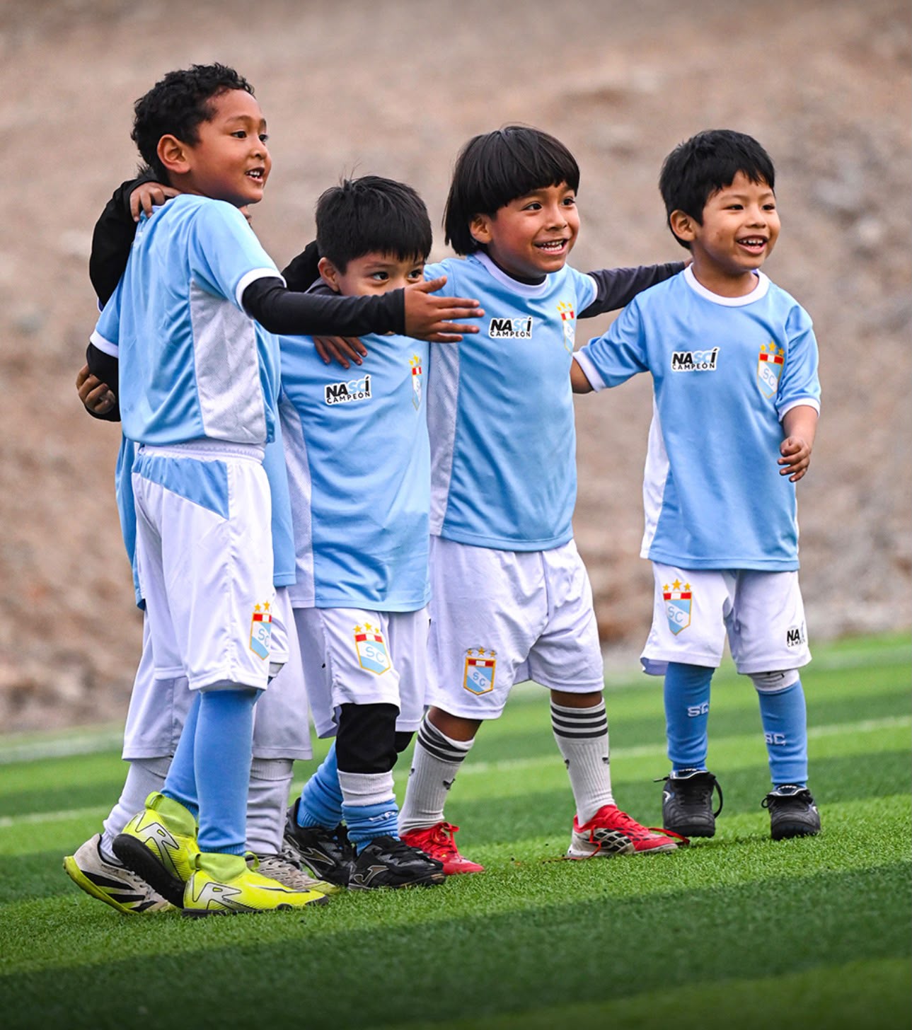 Cuatro compañeros de la academia abrazados en la cancha